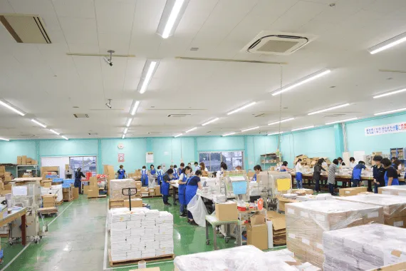 手作業で訂正シールを貼るシール貼り代行の作業現場